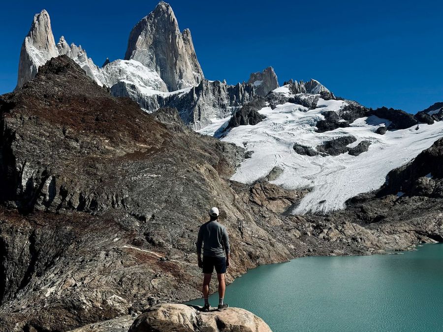 Standing on a rock above a glacial lake, looking toward the Fitz Roy massif in Patagonia